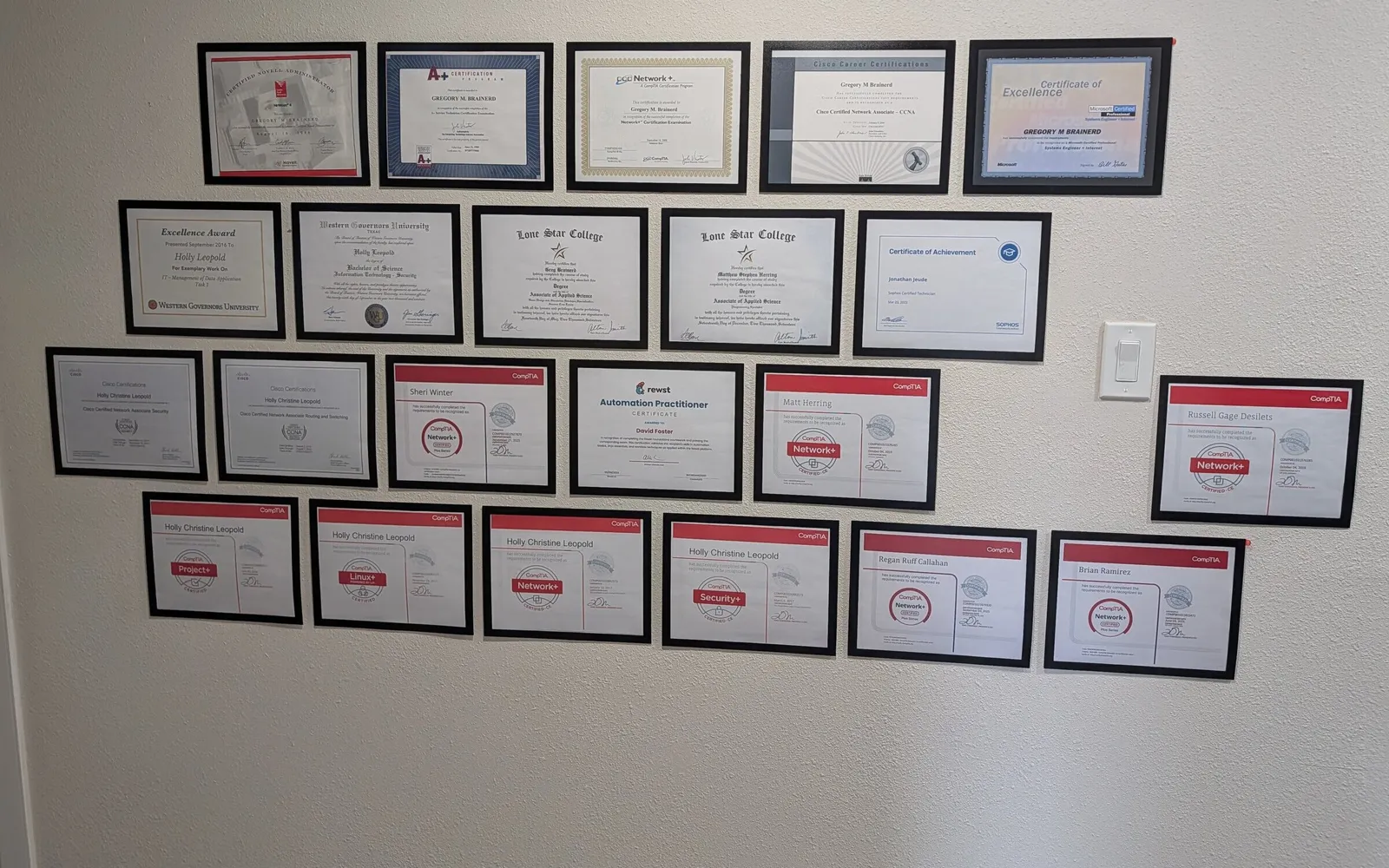Framed technician certifications on the wall at Braintek's Spring office: CompTIA, Cisco, Microsoft, Sophos, and IT degrees