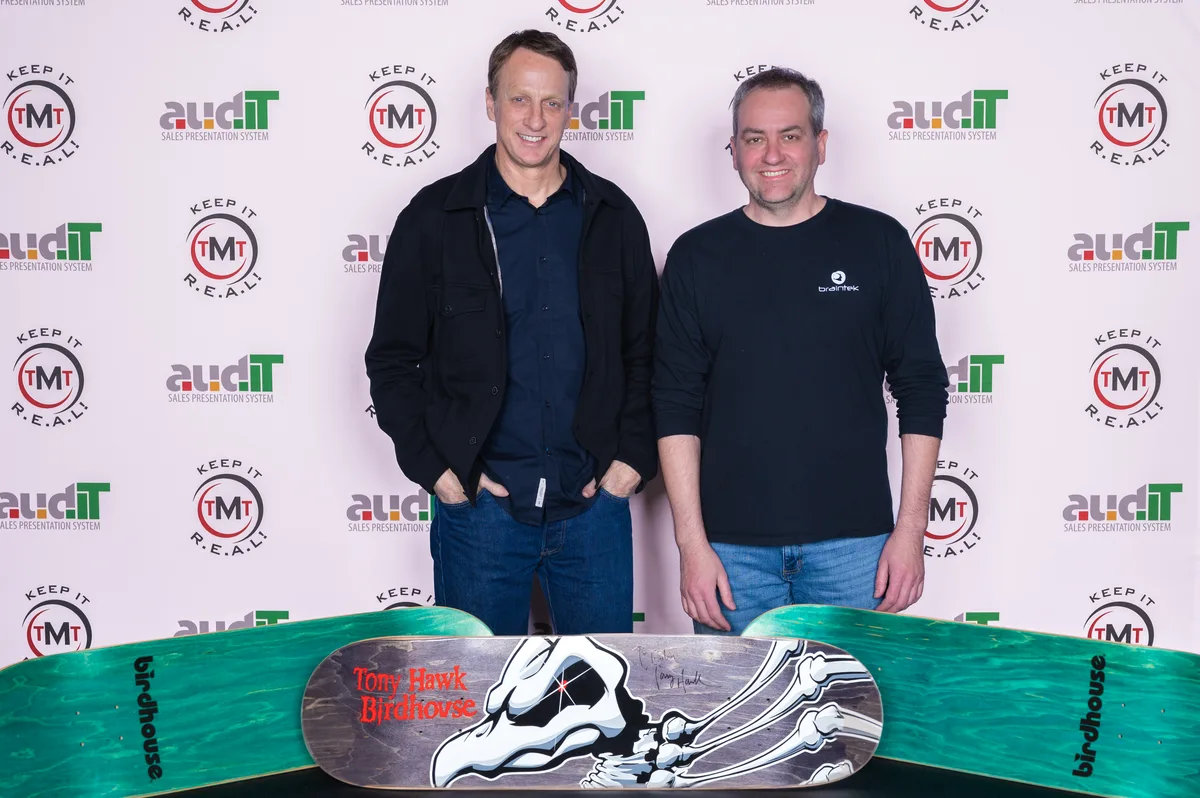 Greg Brainerd with skateboarding legend Tony Hawk and a signed Birdhouse deck