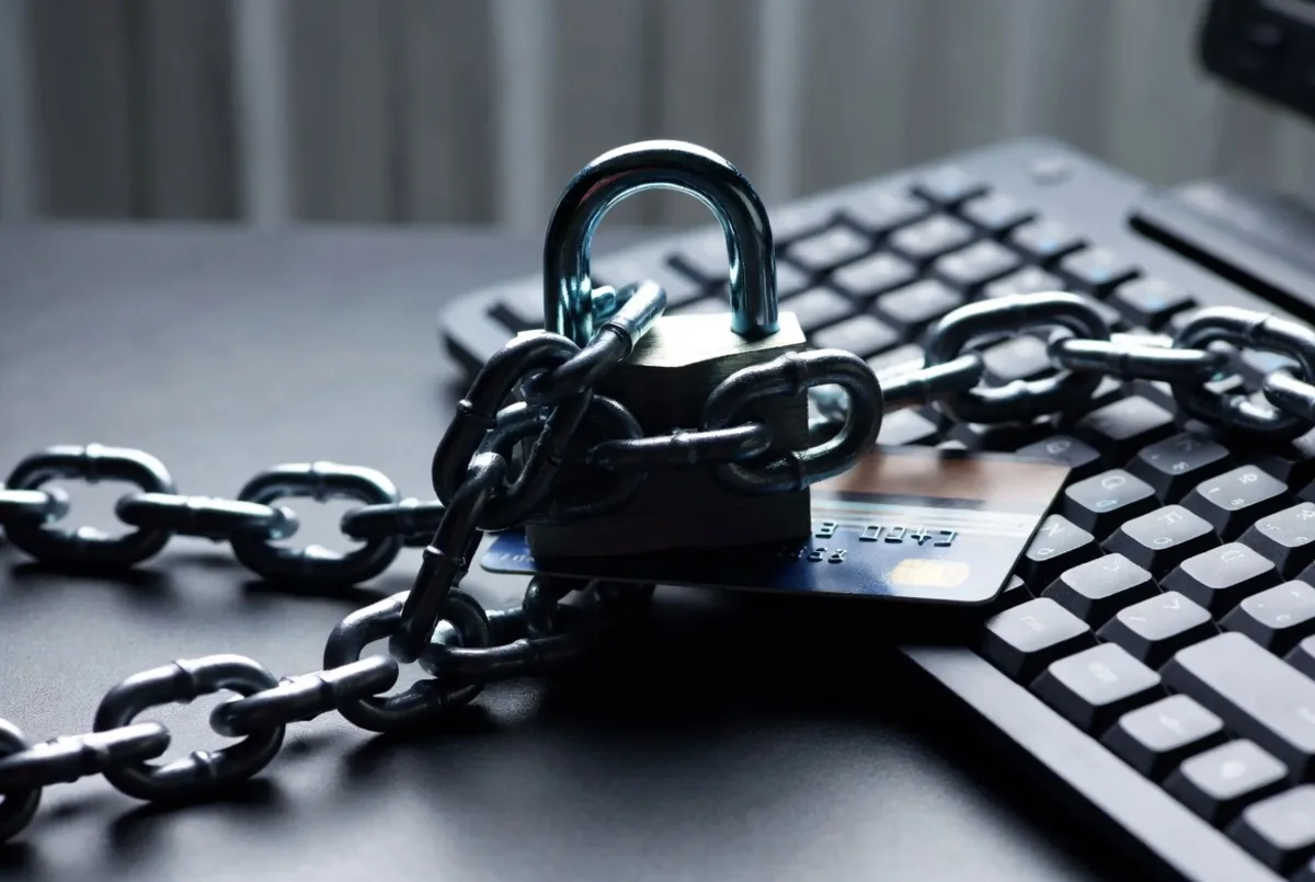 A padlock and chain over a credit card and keyboard