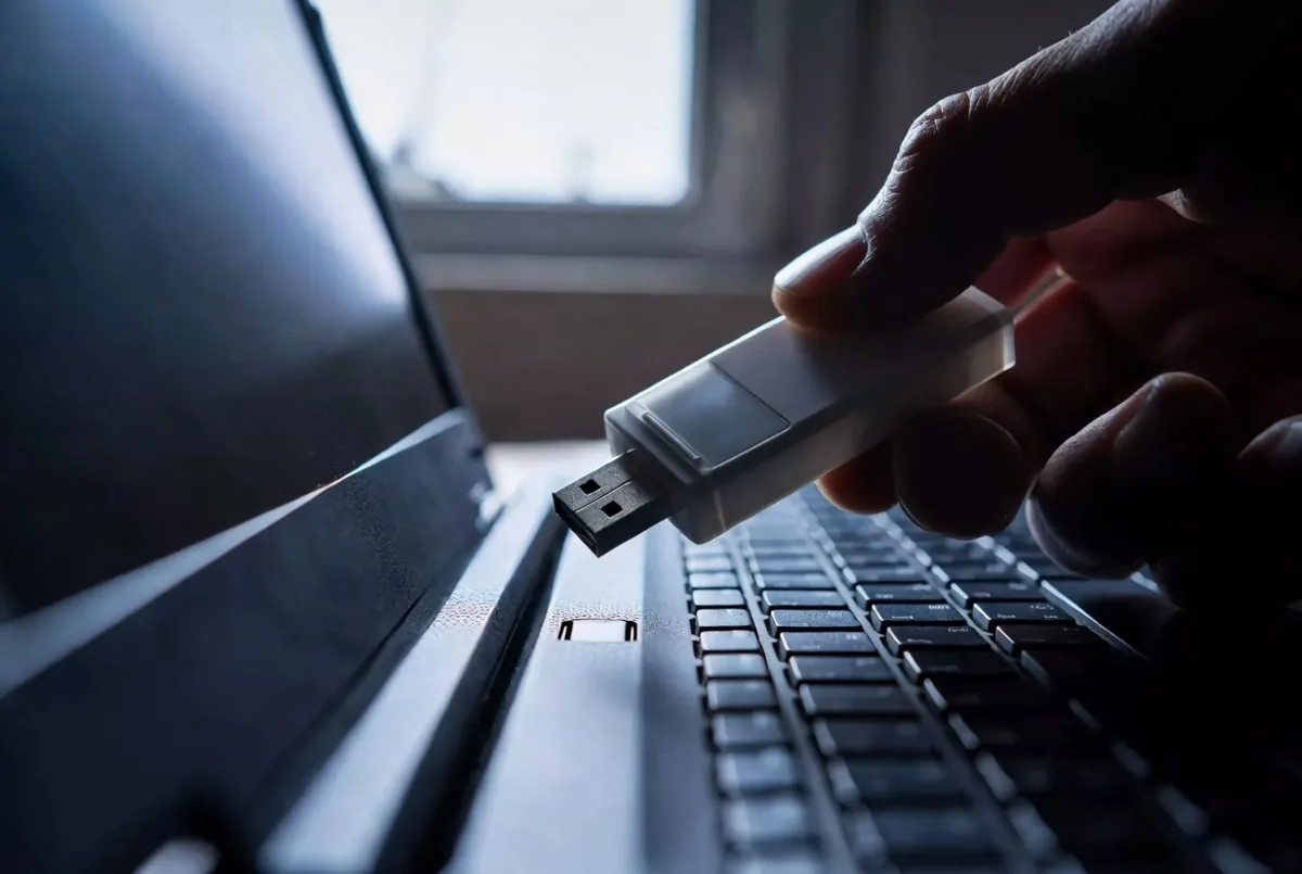 A USB drive being inserted into a laptop