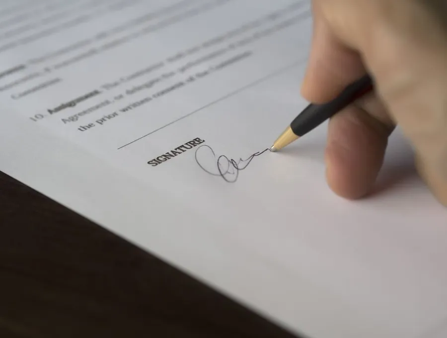 Signing a financial document — Braintek FTC Safeguards compliance for CPA firms