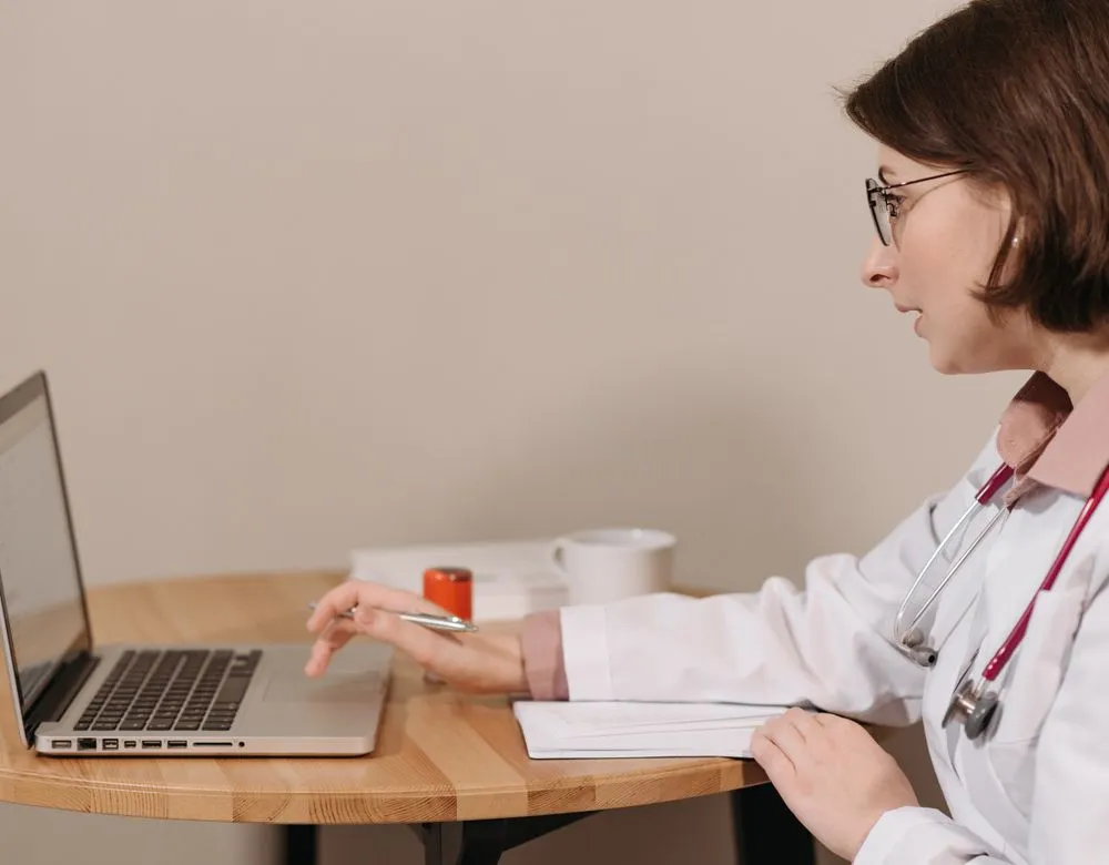 A physician working on a laptop in a medical practice — Braintek HIPAA-minded healthcare IT