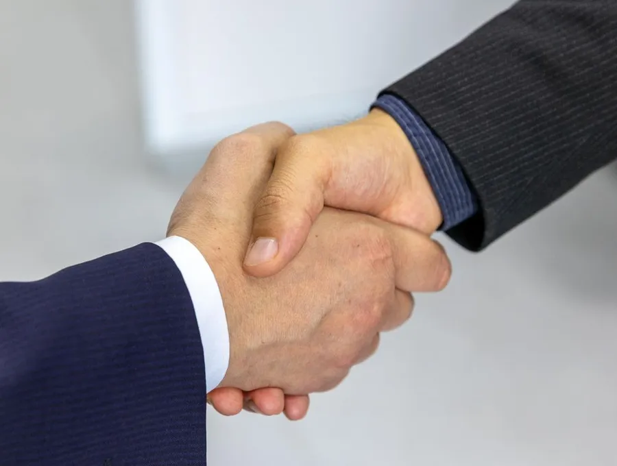 A business handshake closing a deal — Braintek IT for professional services firms