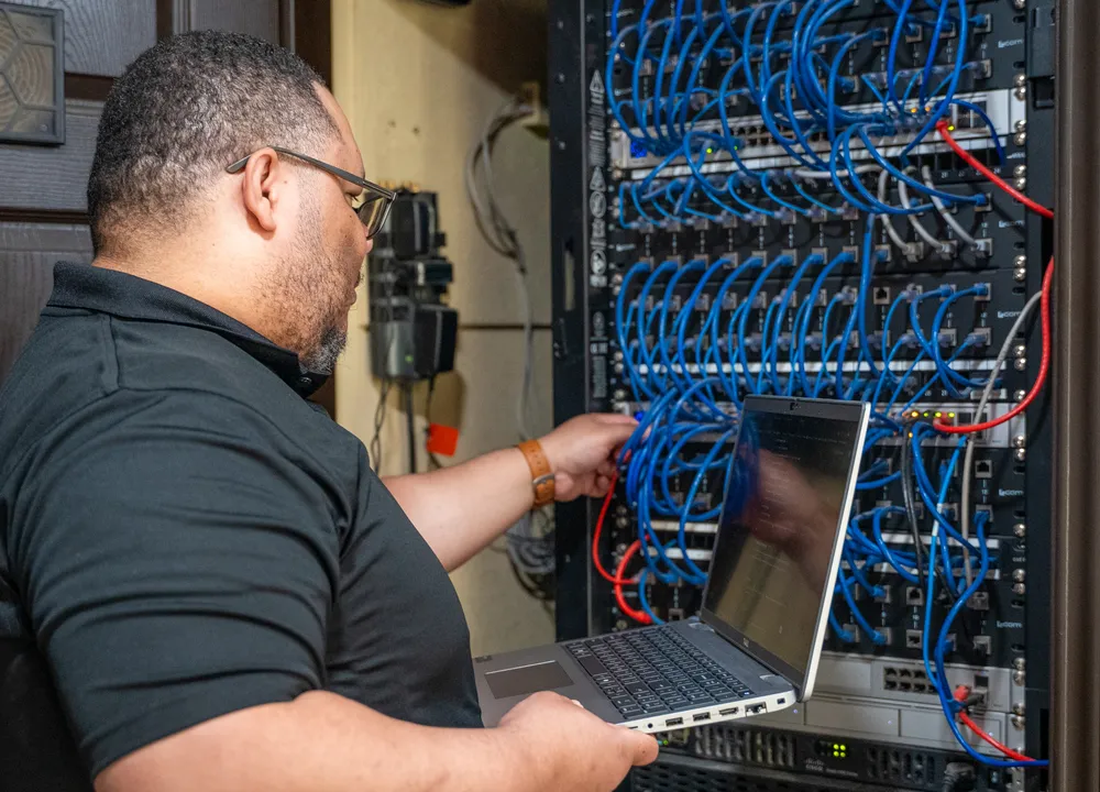 Braintek technician servicing a network rack on-site